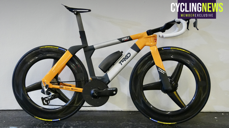 A Toot Racing bike leaning against a white wall