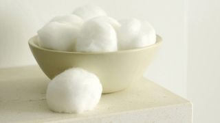 cotton wool balls in a bowl as a handy kitchen cleaning hack to keep bins smelling