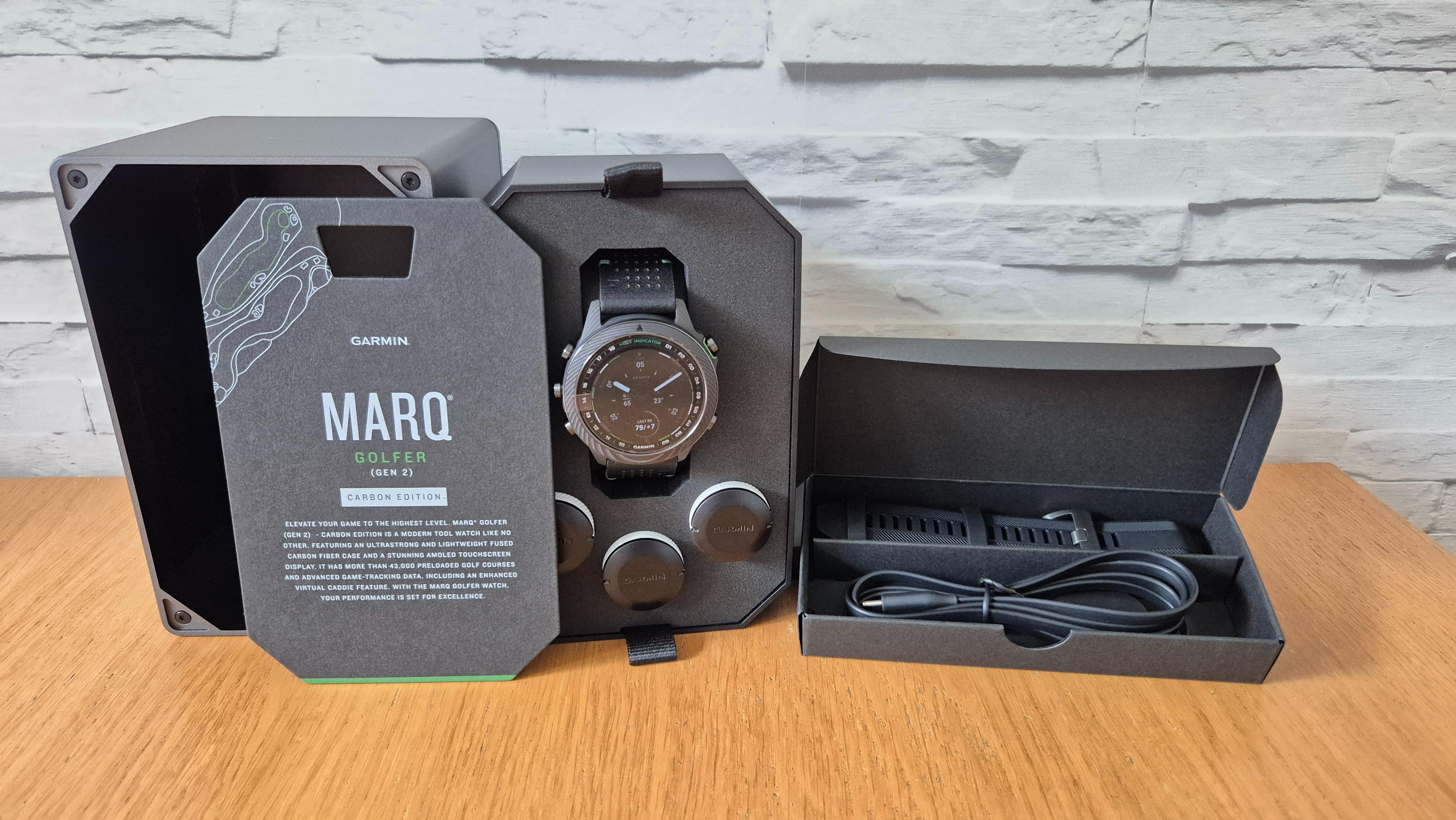 The Garmin MARQ Golfer (Gen 2) boxed and on a wooden surface