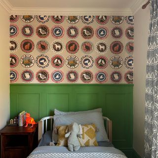 Kids bedroom with green half panelled wall topped with patterned wallpaper