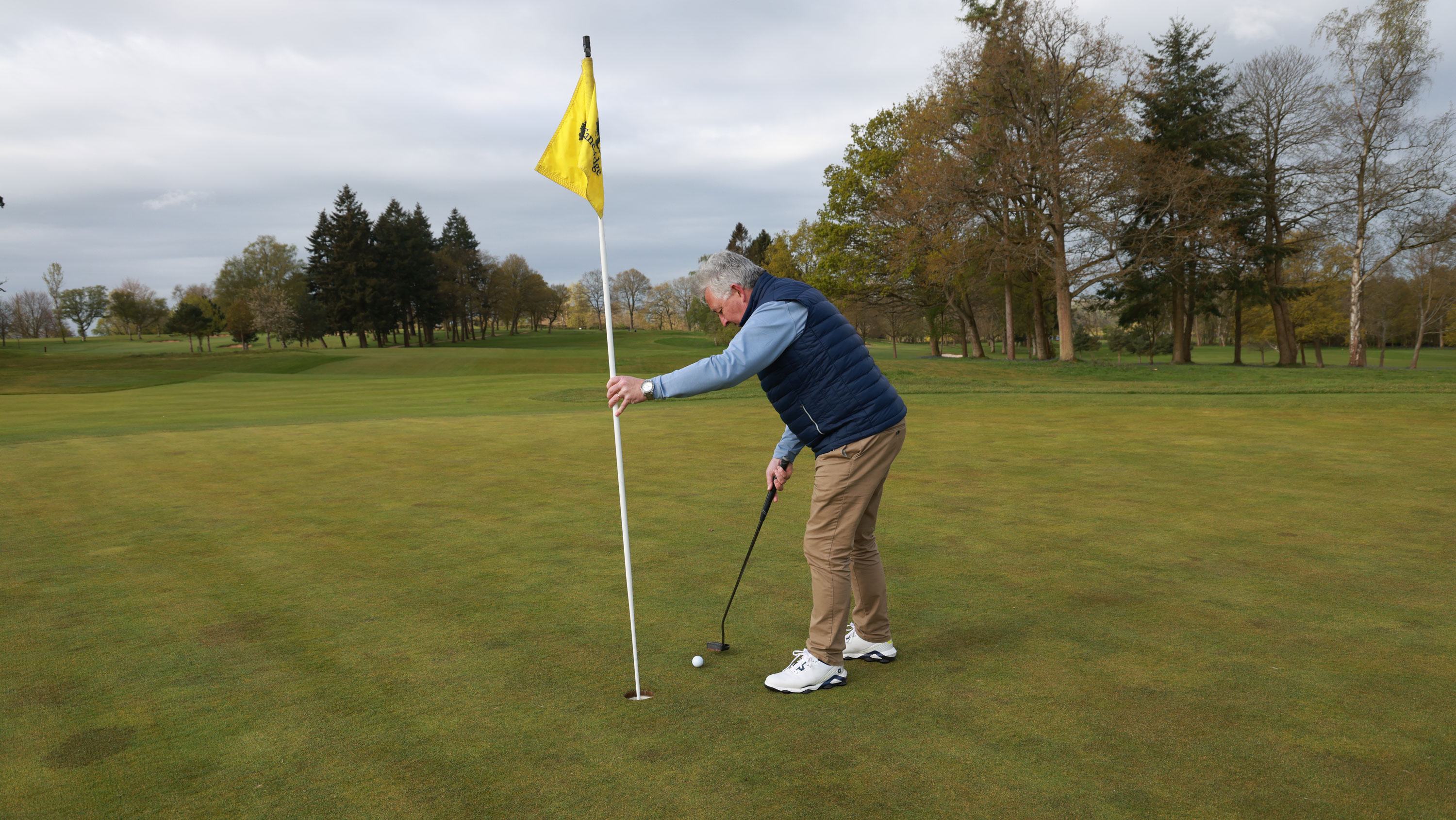 Can you hold the flagstick as you tap in?