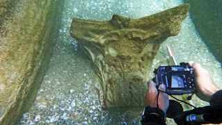 A diver photographs a piece of 1,800-year-old marble at the bottom of the sea. 
