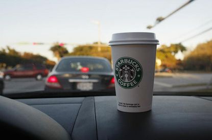 A Starbucks cup in a car.
