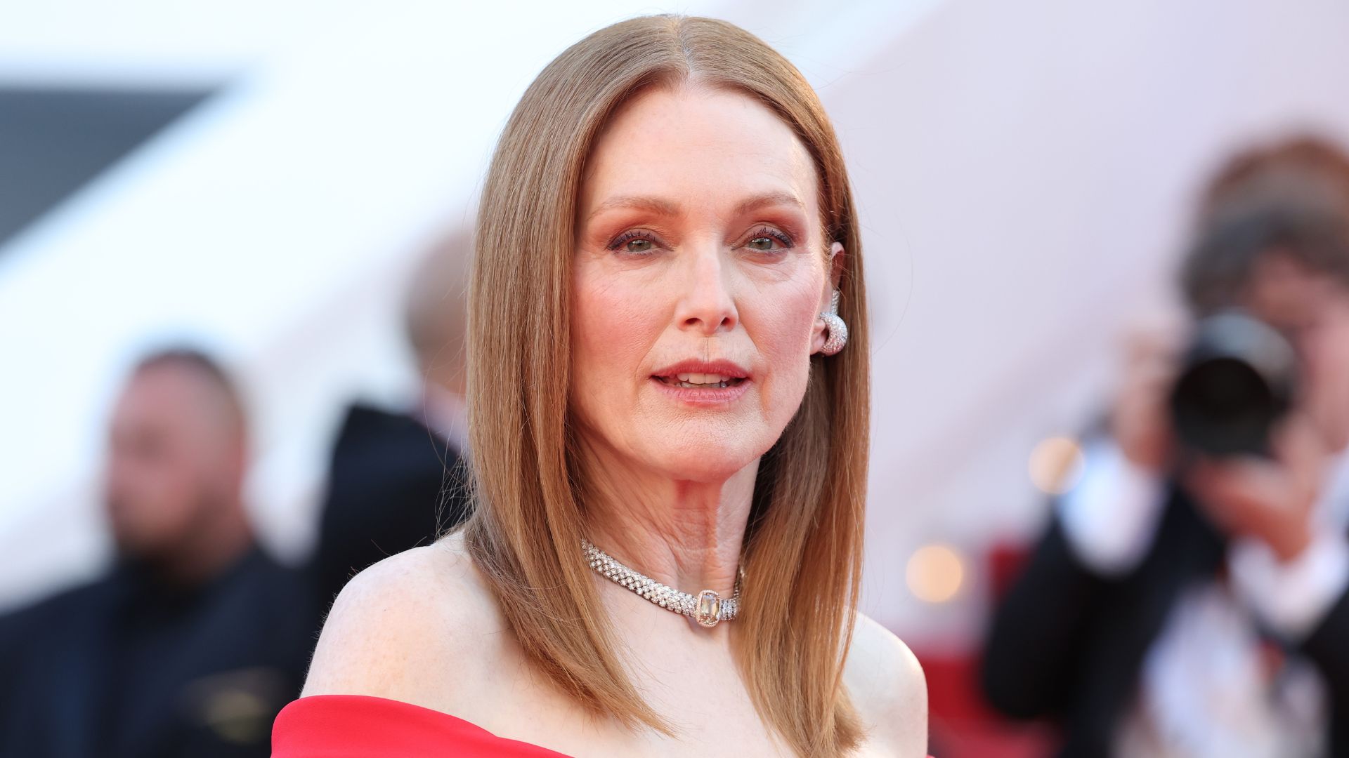 Julianne Moore pictured in a red dress with diamond earrings and copper hair