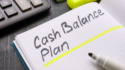 The words "cash balance plan" are written in a notebook next to a calculator.