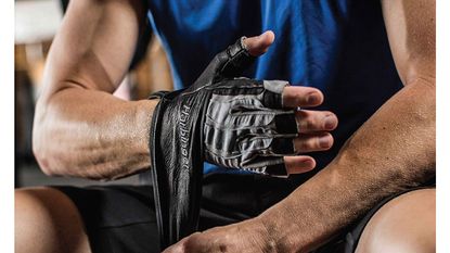 best gym gloves: Pictured here, a bodybuilder putting on gym gloves