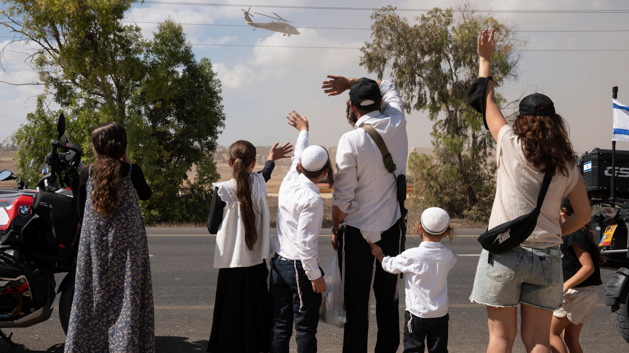 People waving at a helicopter