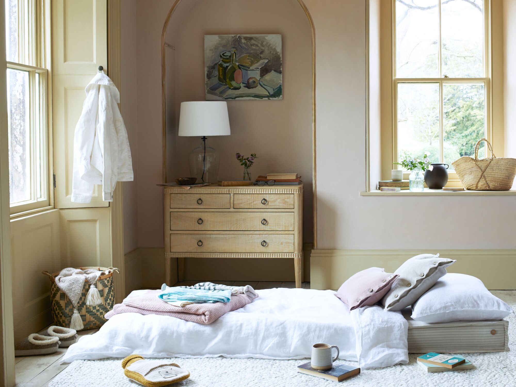 A bedroom with floor cushions making a temporary bed