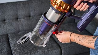 the dyson gen5detect cordless stick vacuum in prussian blue and copper, showing its cleaning head and attachment tools