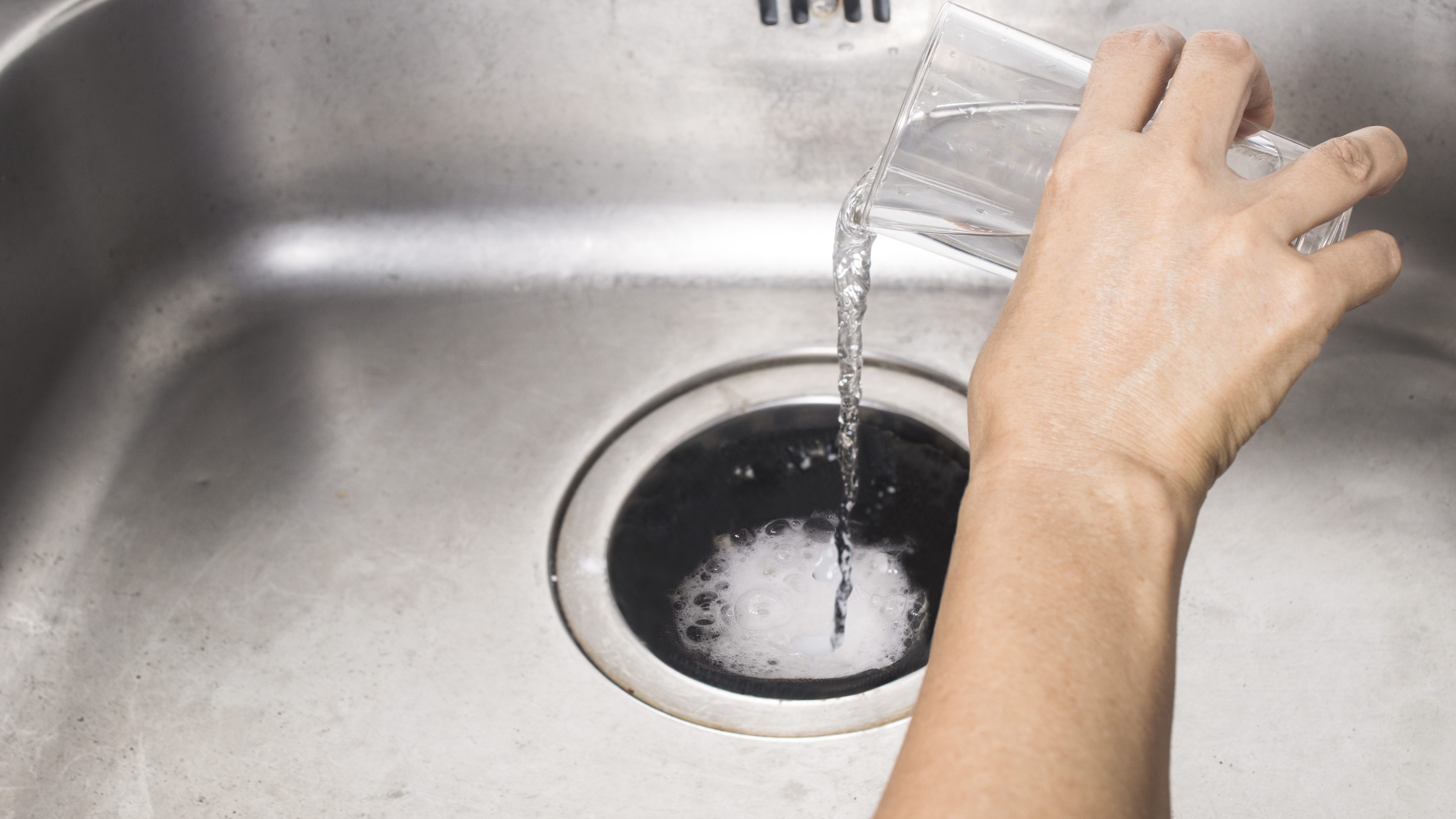 Pouring baking soda and vinegar down drain