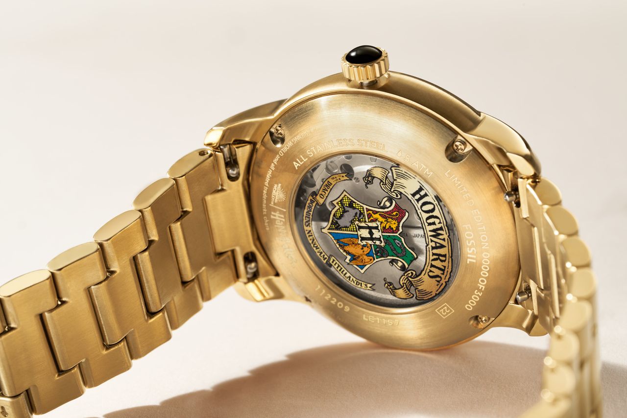 A Harry Potter x Fossil watch from behind, showcasing the exhibition caseback, on sandstone