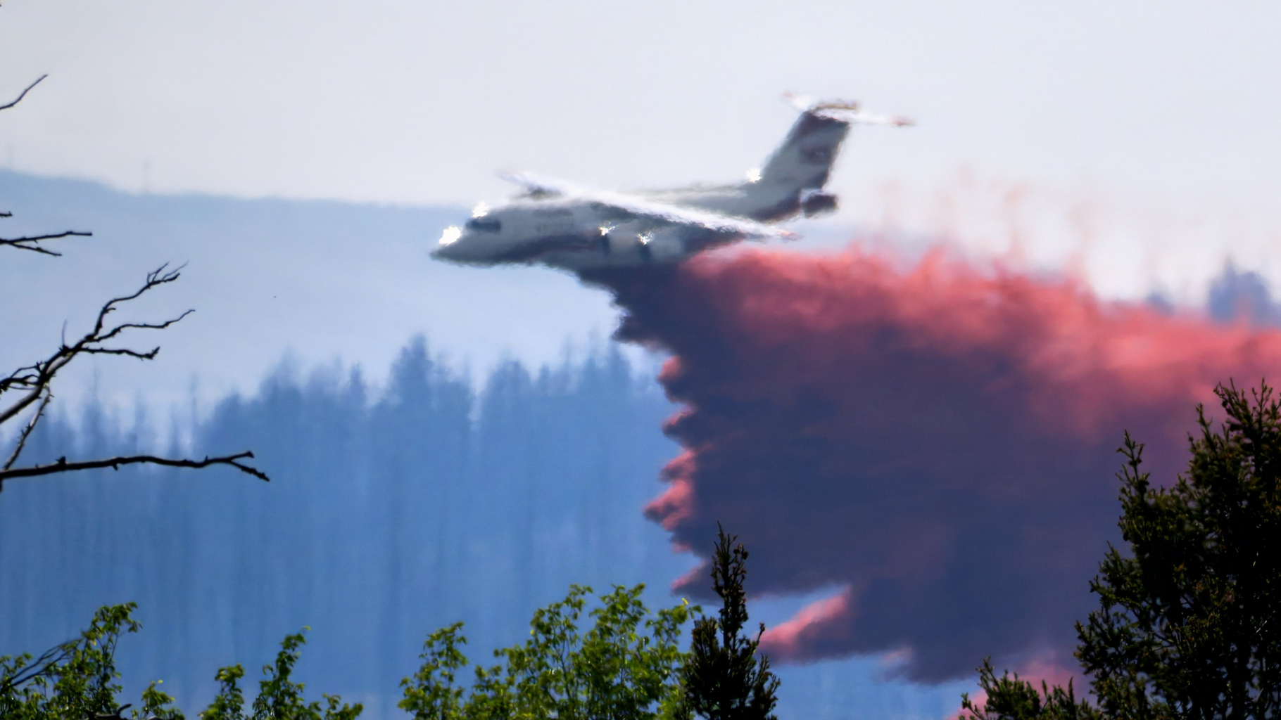Plane dropping red retardant on wildfires in Canada