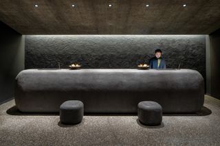 dark minimalist reception at Kai Yufuin by Kengo Kuma