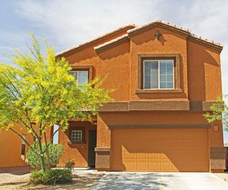 house with garage painted to match ochre stucco