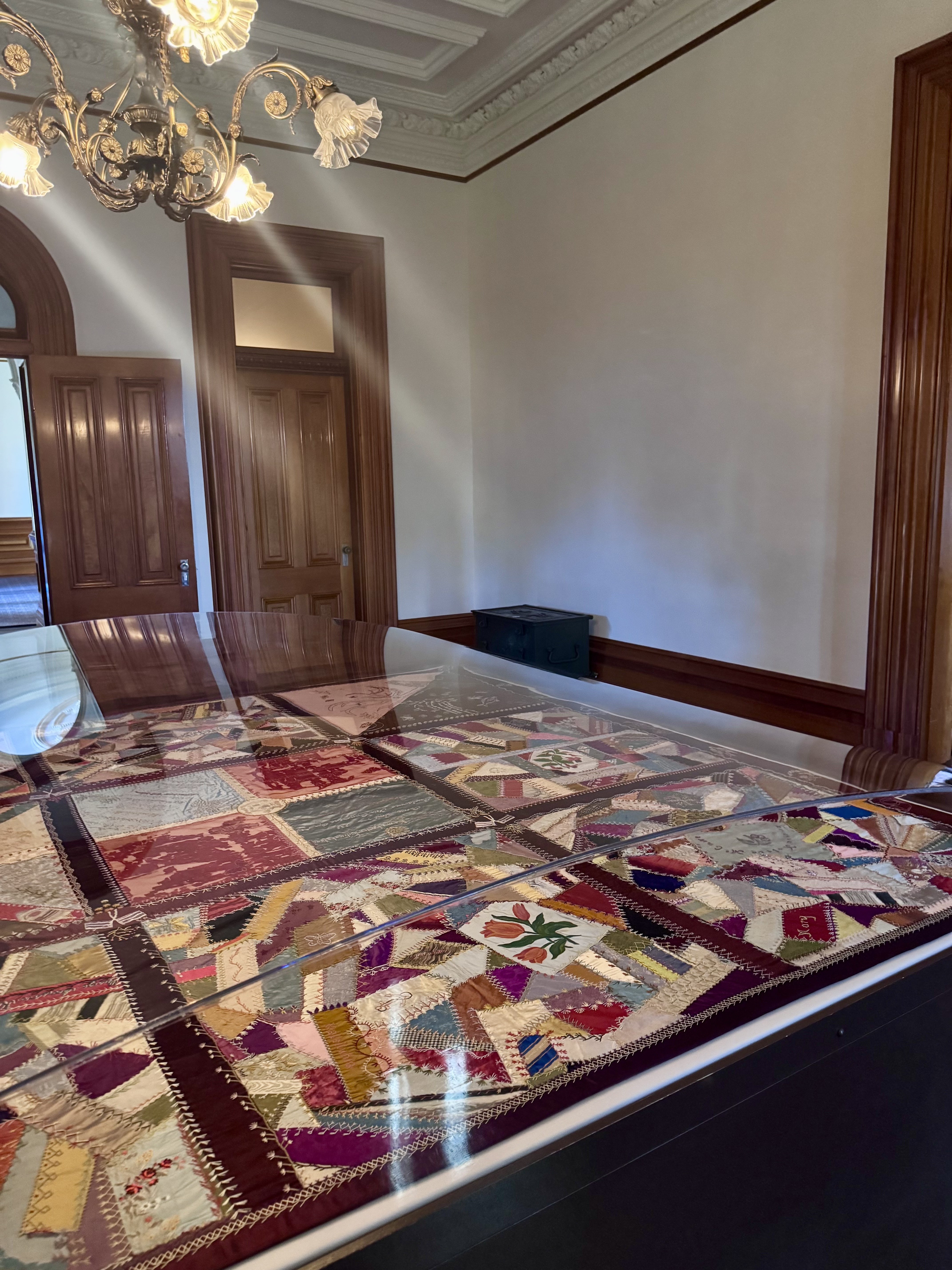 A case holding a quilt in a room in 'Iolani Palace