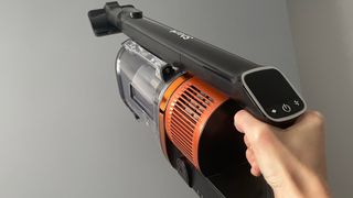 The Shark Anti Hair Wrap Cordless Stick Vacuum Cleaner with PowerFins & Flexology being used in handheld mode to clean stairs