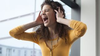 Loudest headphones: Woman listening to loud music on headphones