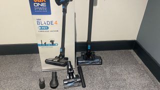 The Hoover Blade+ out of its box with the tools on the floor