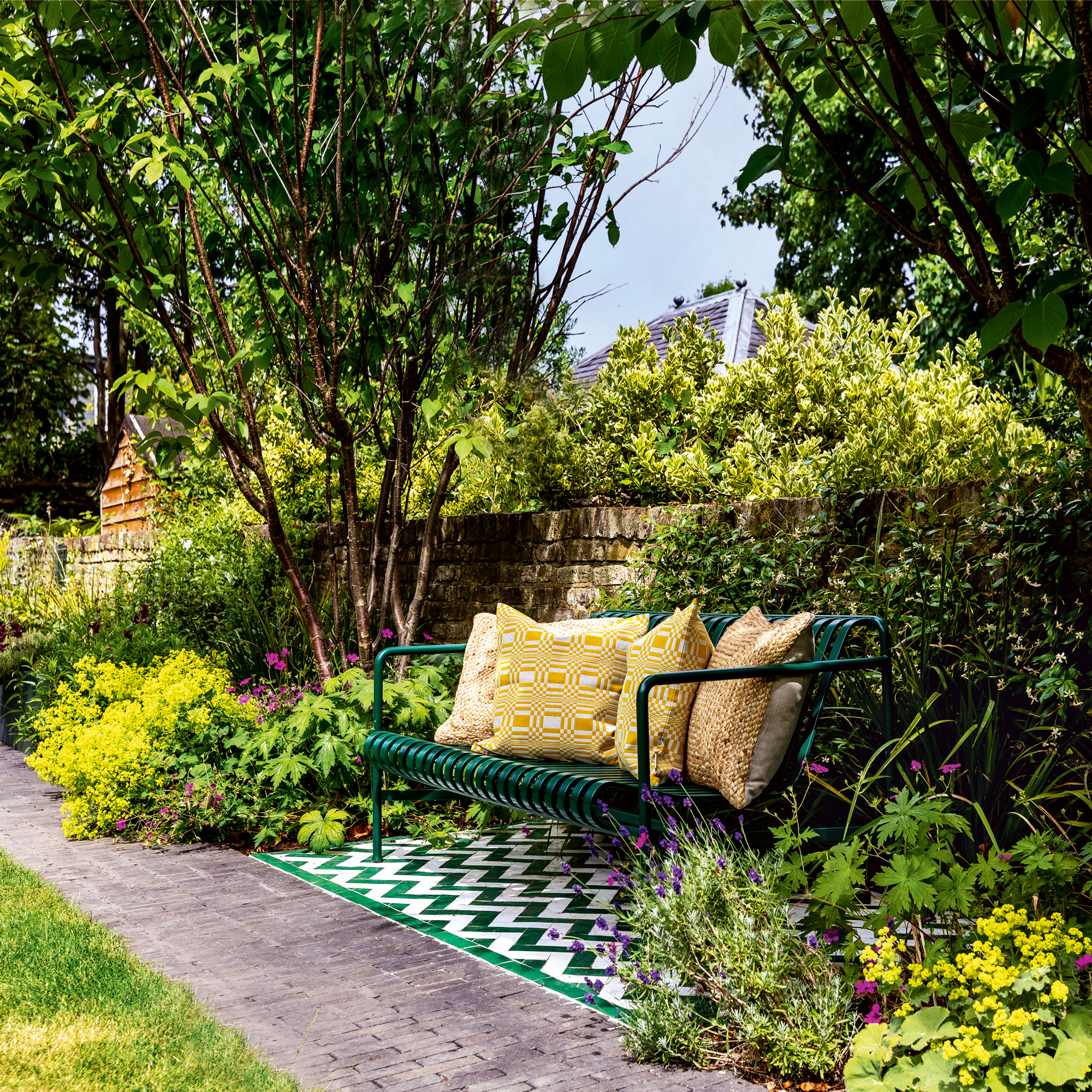 garden makeover with green bench and patterned tiles