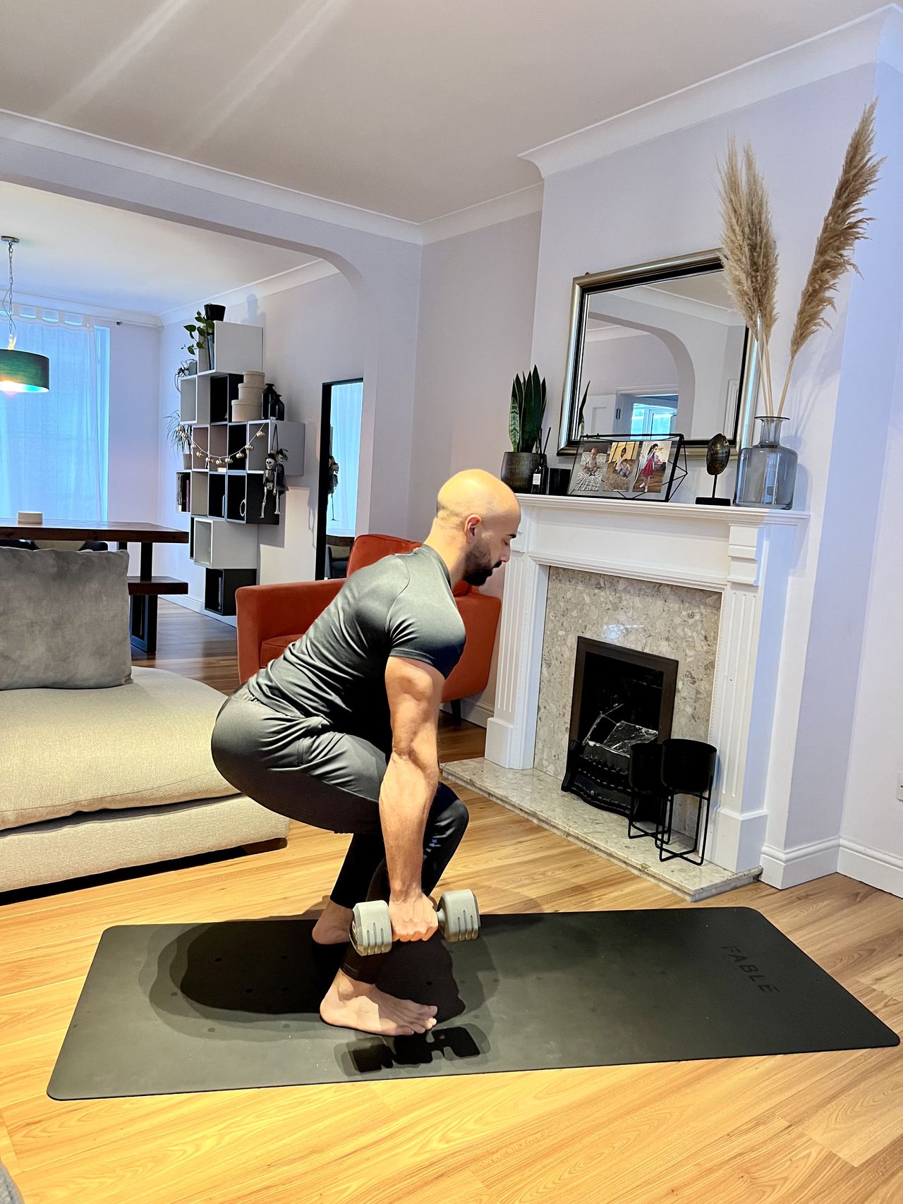 Personal trainer Ali Malik demonstrating the suitcase squat