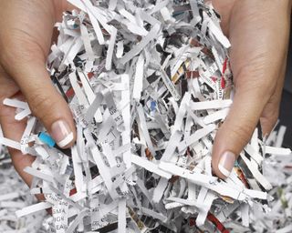 Hands hold shredded paper