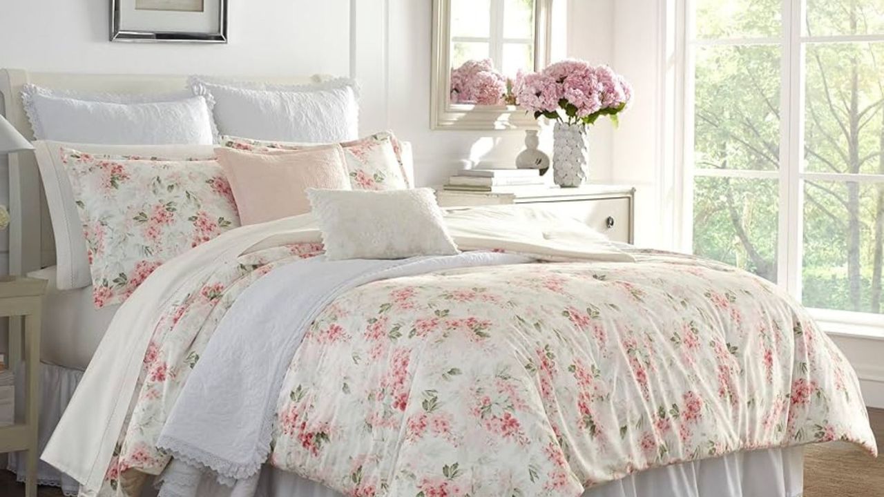 Laura Ashley bedding on a bed against a white wall.