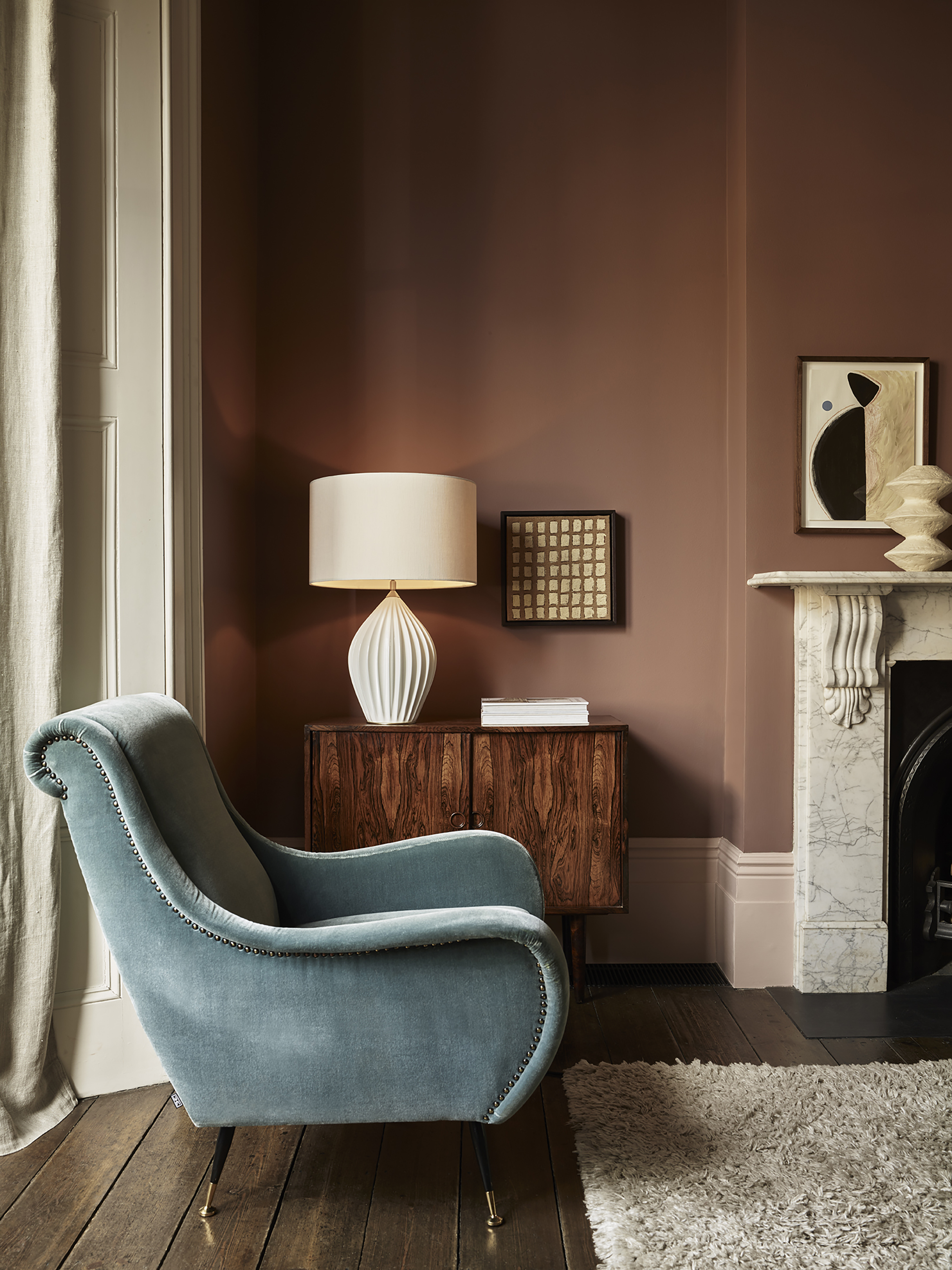 Dusky pink living room with blue velvet armchair and Original BTC Fin Queen table lamp
