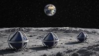 three spherical objects consisting of spherical metal frames enclosing tetrahedral solar panels sit on a dusty grey surface, with earth visible in a starry black sky in the distance