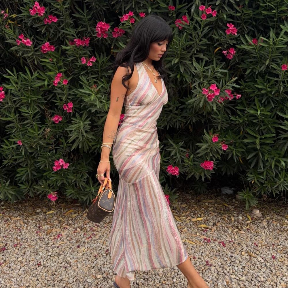 Influencer @summerrachelwarren wears a striped dress with a Louis Vuitton bag.