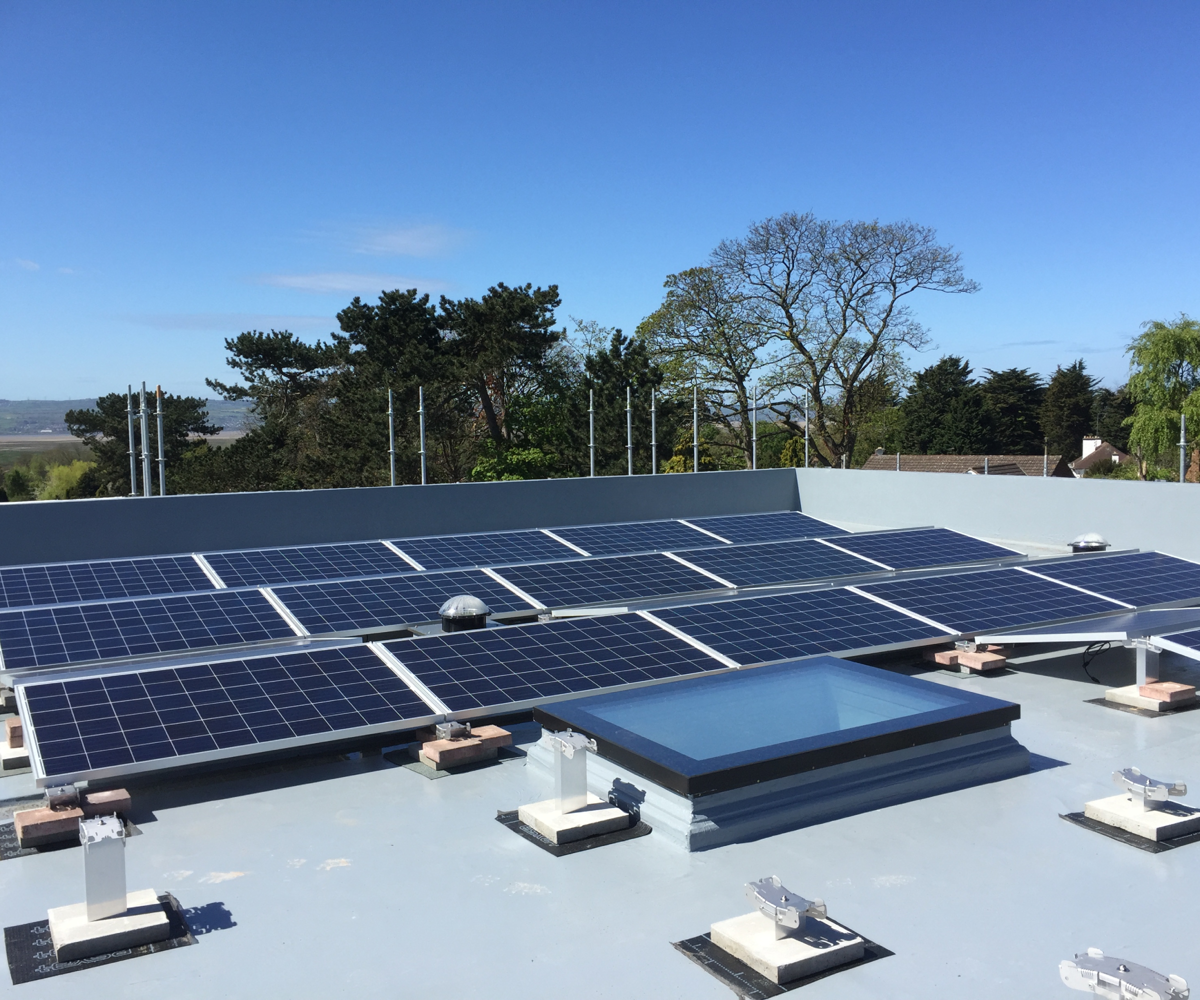 solar panel array mounted on flat roof with rooflight