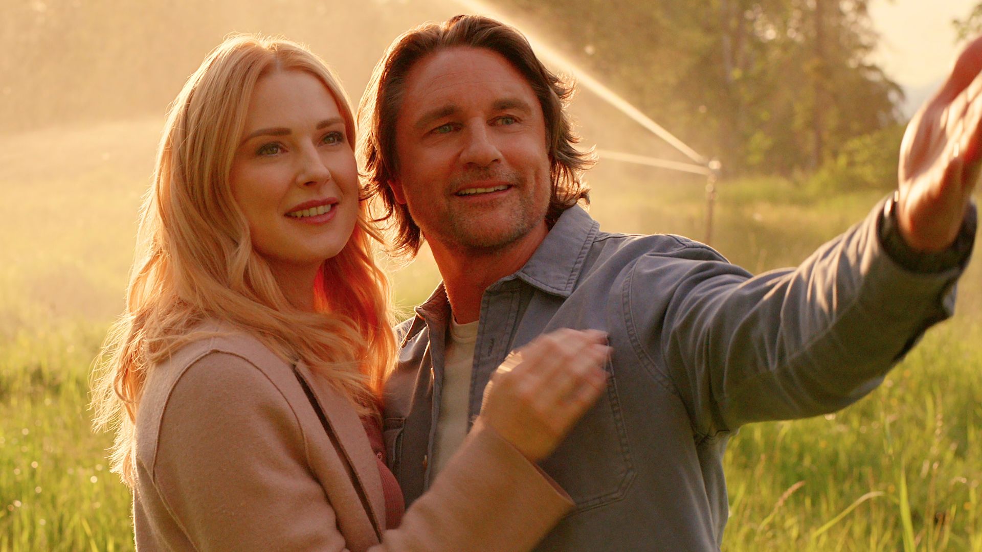 Mel and Jack stand in a sprinkler system