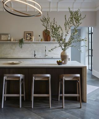 kitchen island with seating and vase of foliage