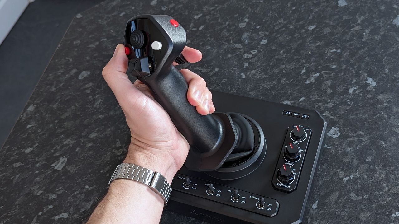 A hand grasping a Honeycomb Aeronautical Foxtrot Aviation Stick, placed on a marble-patterned countertop
