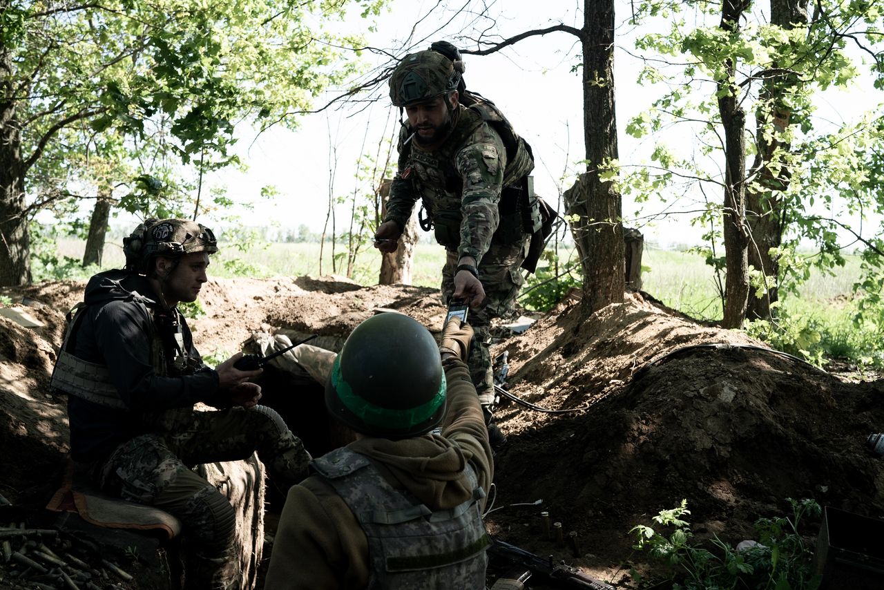 Soldiers on the ground outside with equipment near Bakhmut