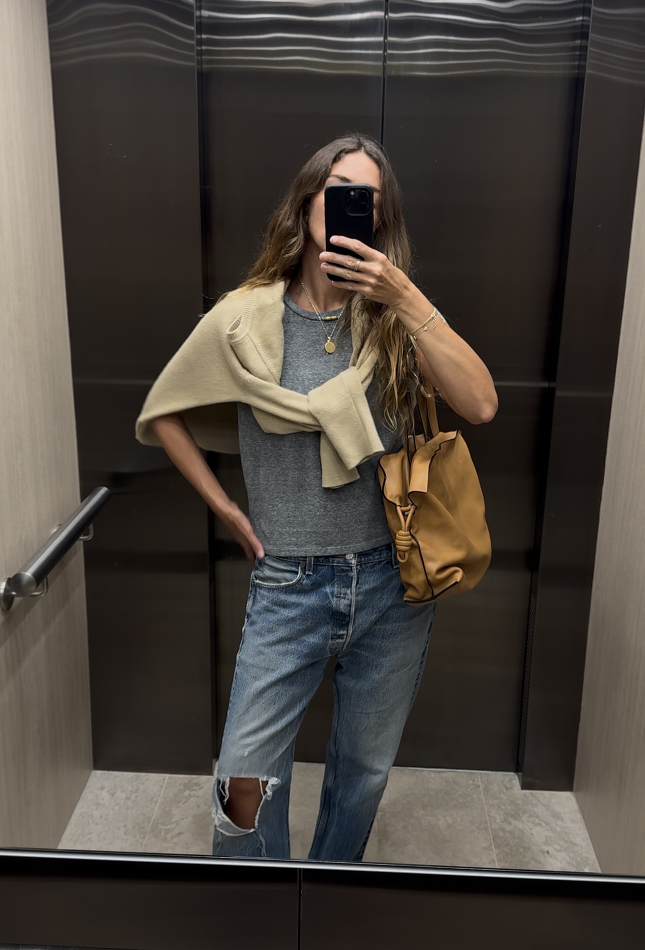 Angie wears a cream knit jumper