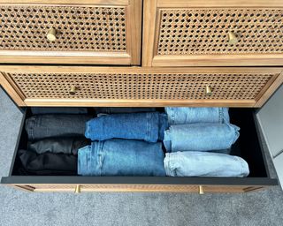 Rattan dressing table drawers with neatly organised denim in a drawer