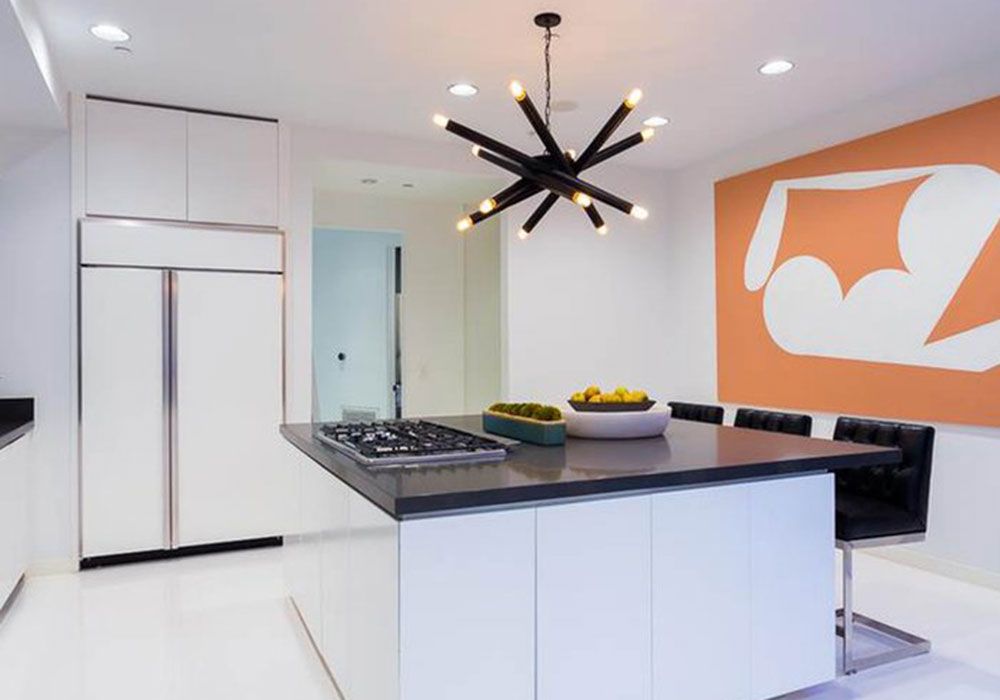 kitchen area with black countertop and white wall