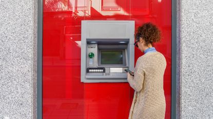 Rear view of woman using an ATM