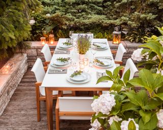 alfresco dining table setup with hydrangea plants growing around