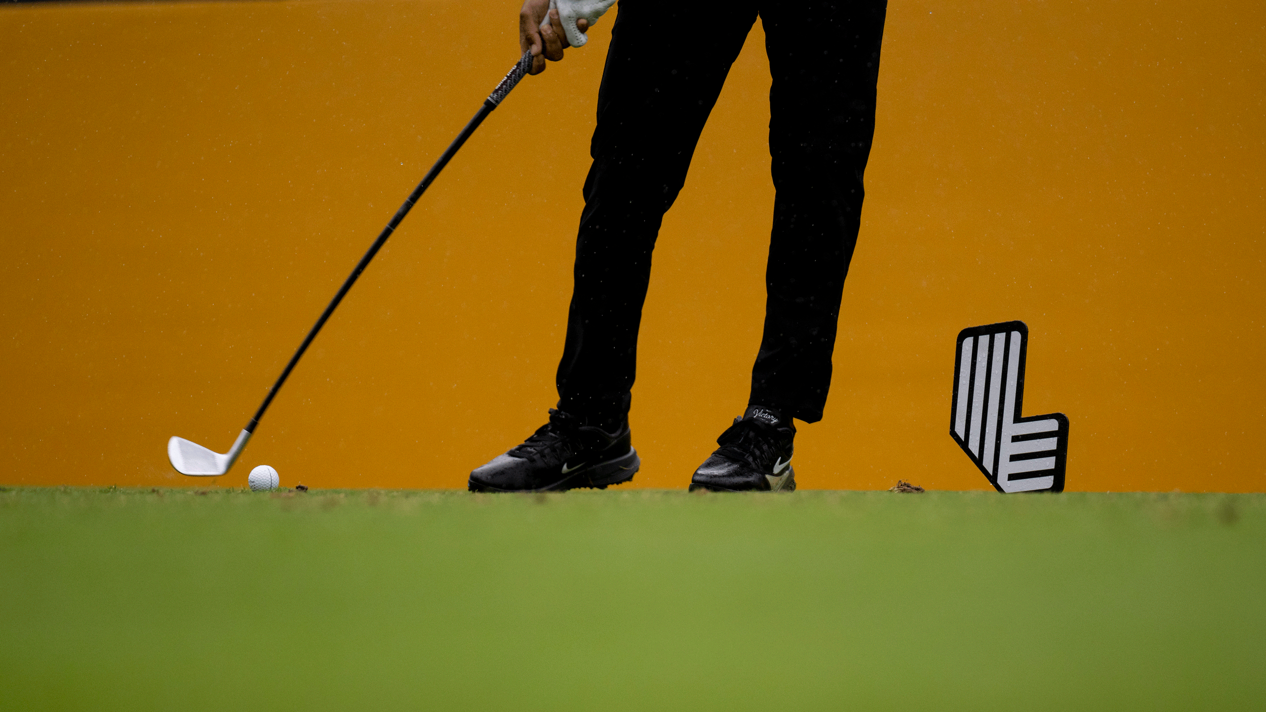 A general view of a LIV golfer's legs, club and ball as they tee off at LIV Golf South Africa