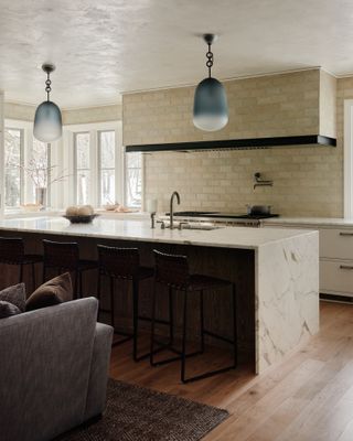 A kitchen with brick walls and hood