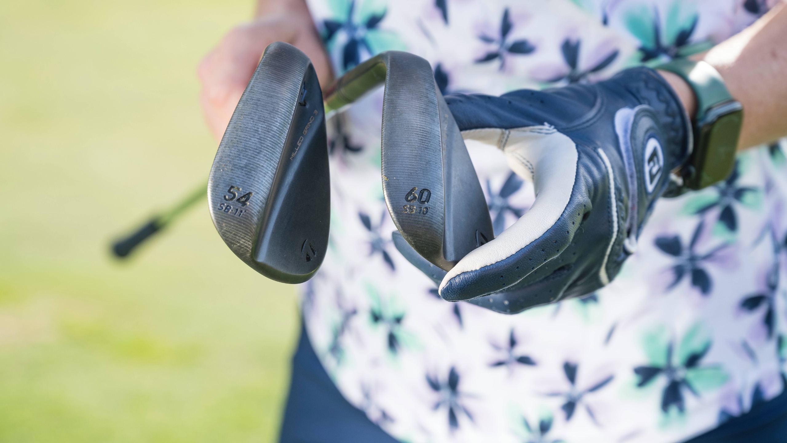 Katie Dawkins holding a 54 and 60-degree wedge