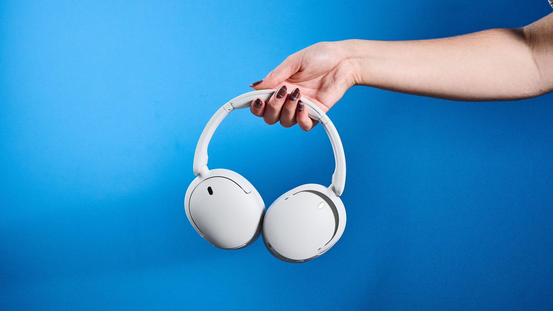 Sony WH-CH730N in white photographed in front of a blue background