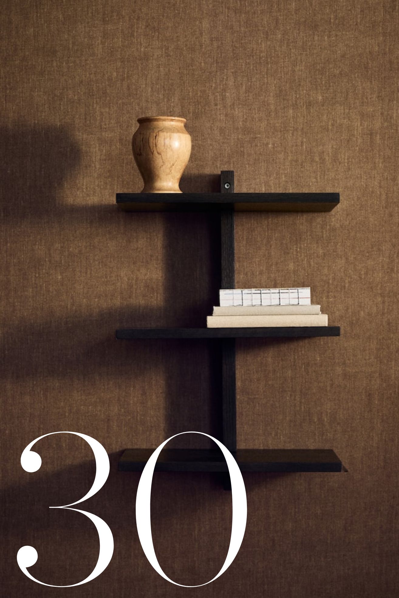 display shelves on grasscloth wallpaper with vases and book