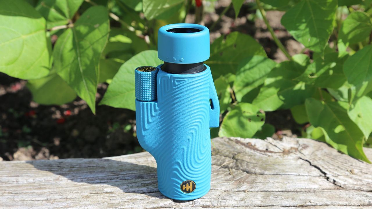 A blue Nocs Provisions 8x32 Field Tube Monocular on a wall