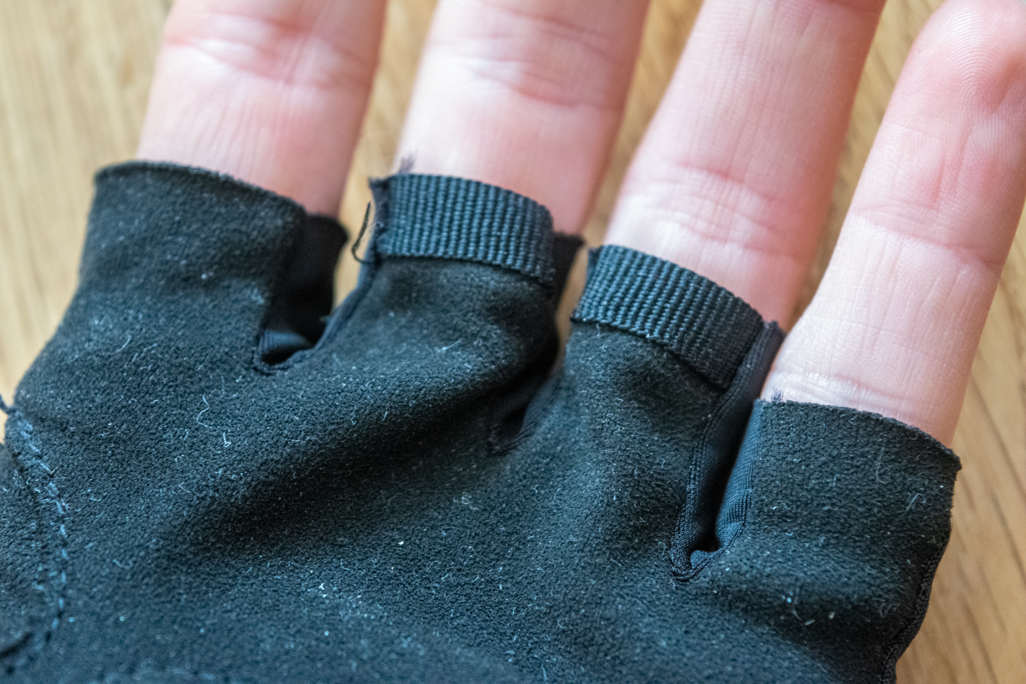 A black Rapha Core cycling mitt on a wooden floor