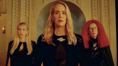 three witches stand in a triangle formation