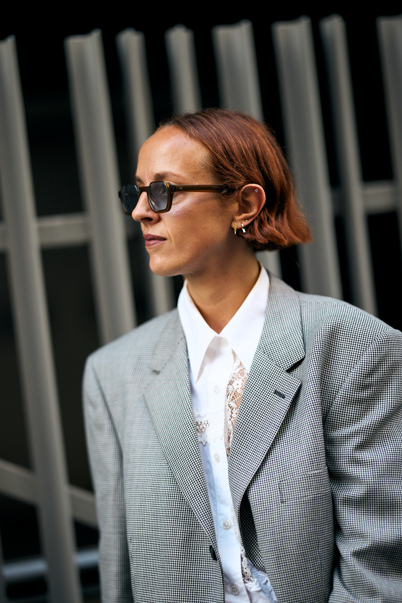 a white woman with a red bob in a gray blazer and white shirt