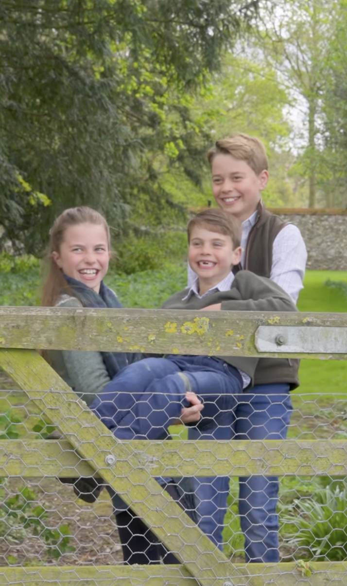 Prince George and Princess Charlotte lifting Prince Louis and laughing