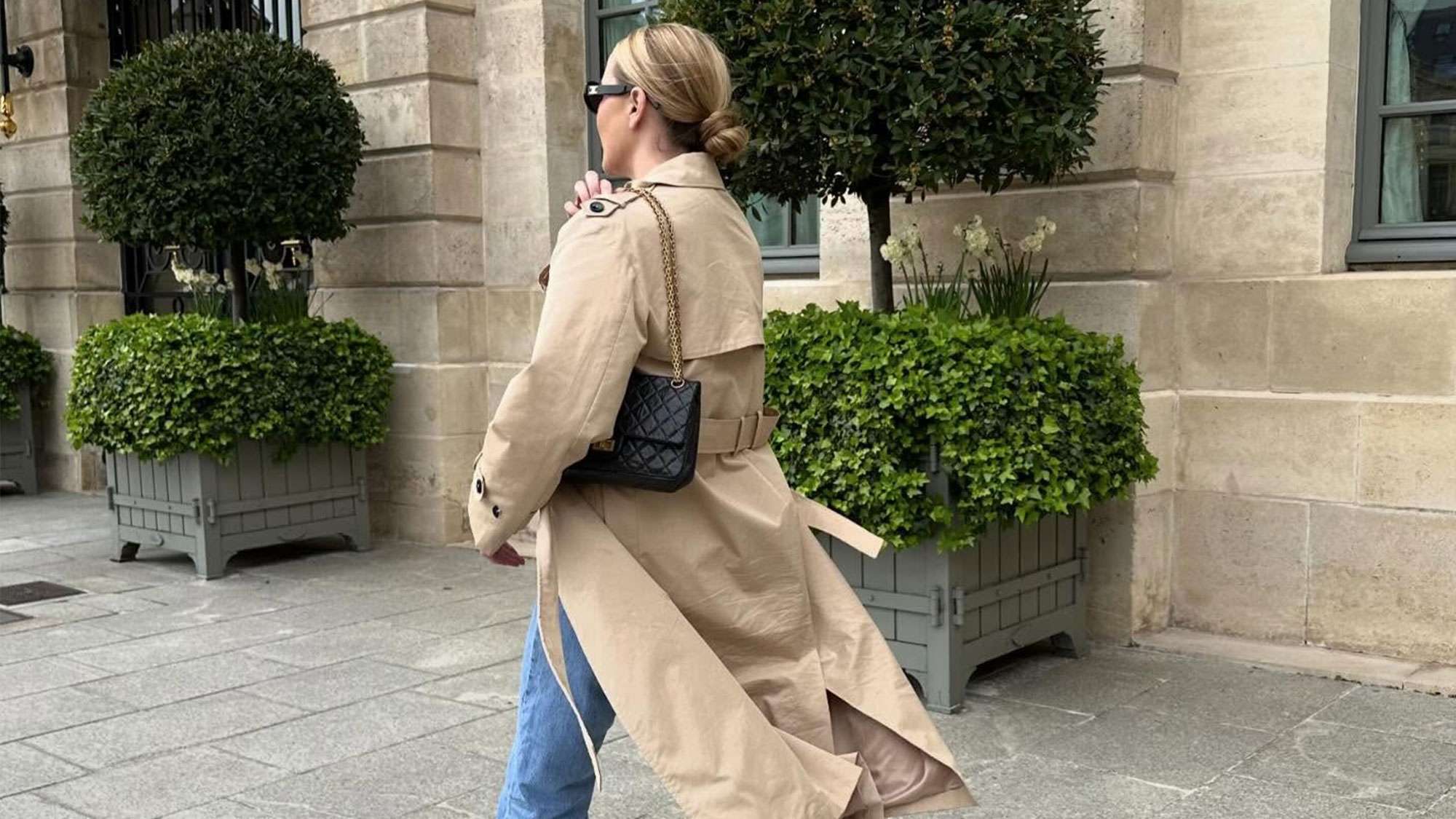 A woman in jeans and a trench coat